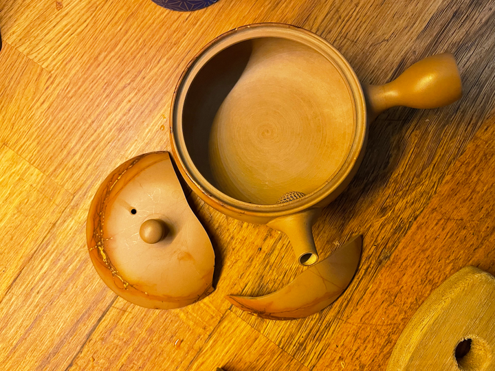 A photo of a fine ceramic tea pot with a broken top.